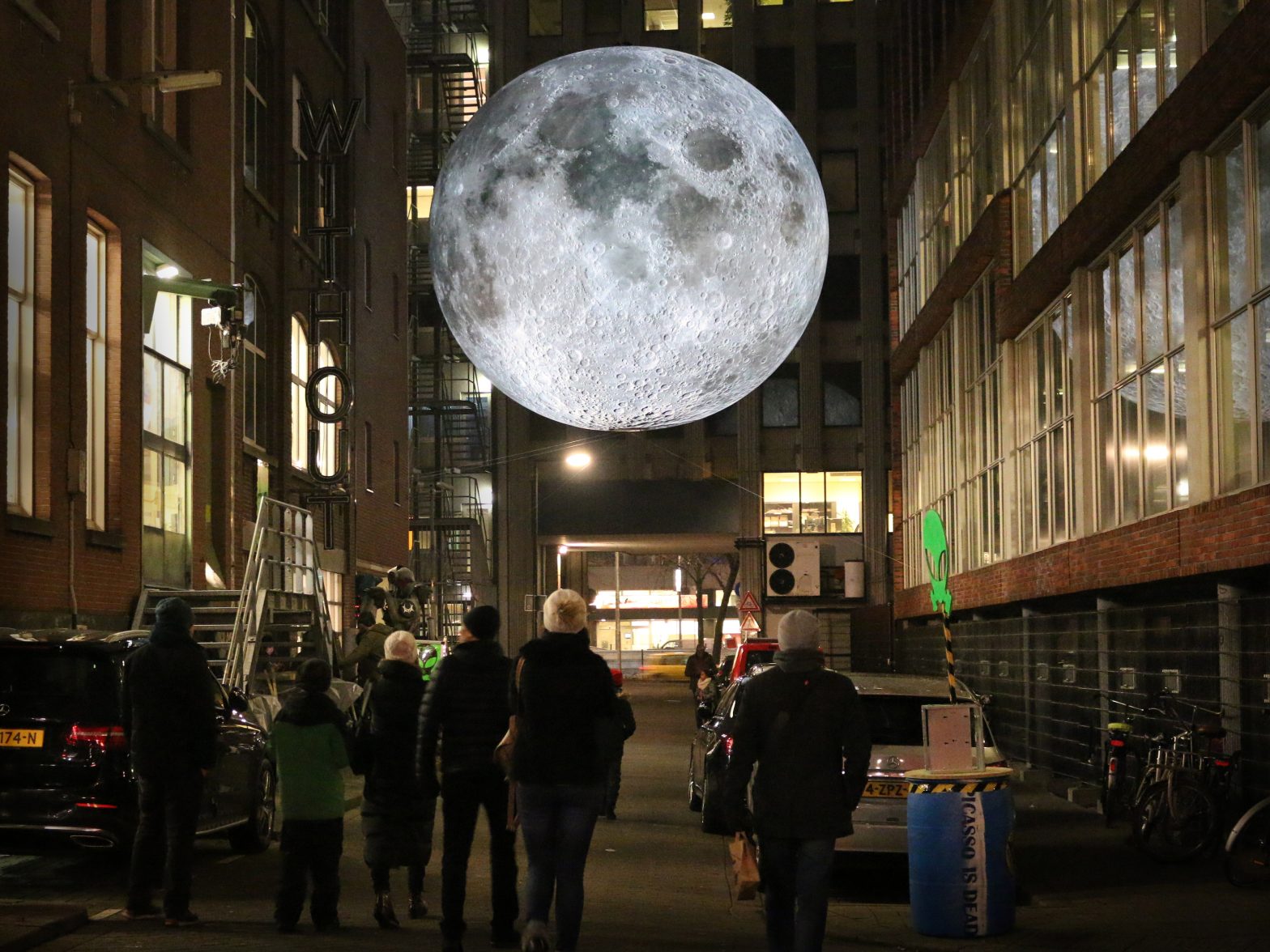 Moon installation on street with people standing looking